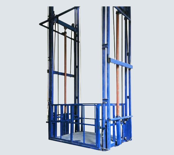 Double mast hydraulic goods lift with guarded platform raised between floors